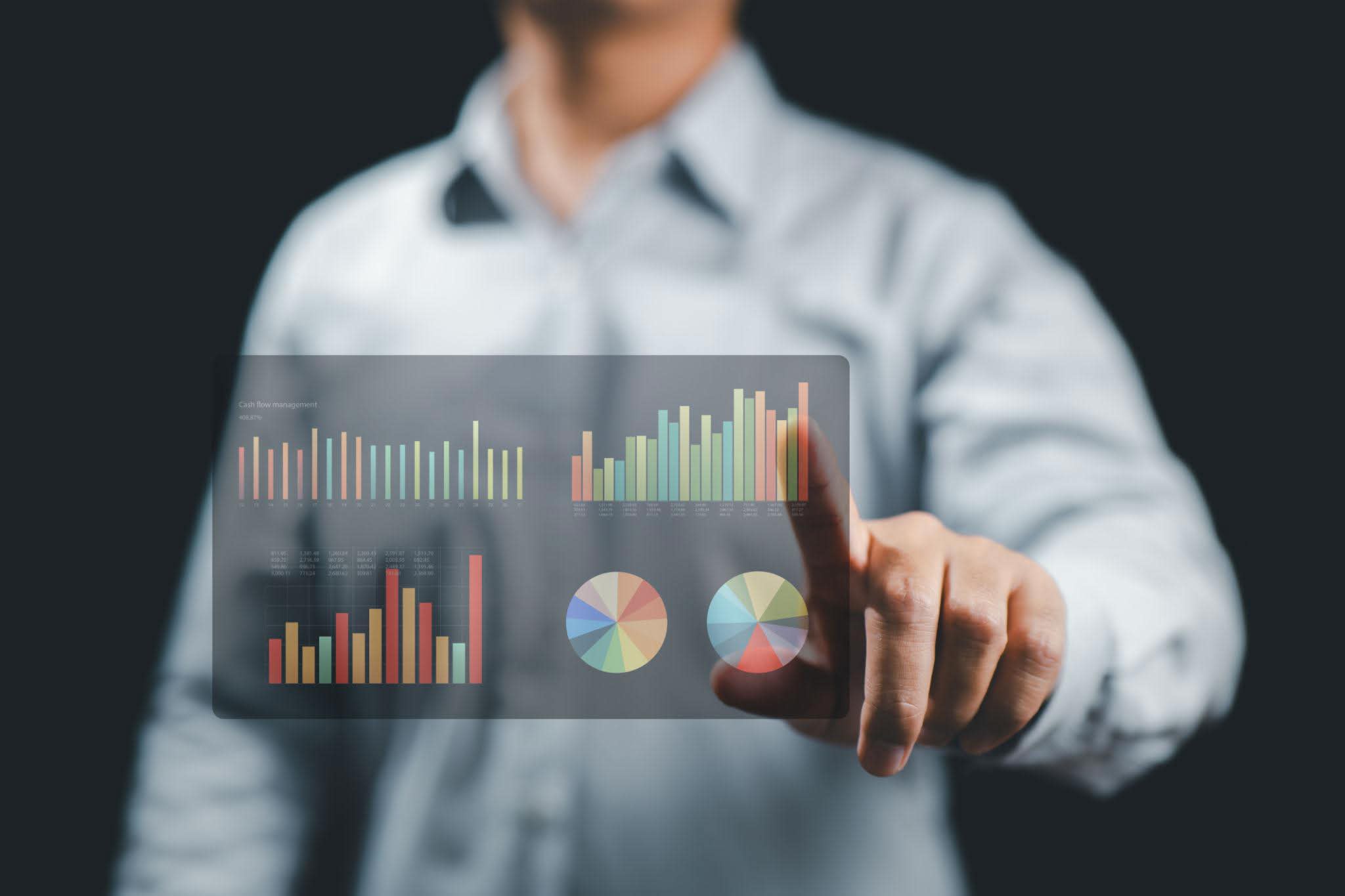 Executive interacting with a translucent analytics dashboard showing pie charts and bar graphs of candidate segmentation data